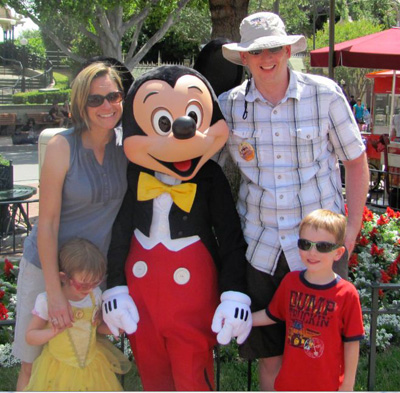 Denise and David Hull with their family and Mickey Mouse at Disney.